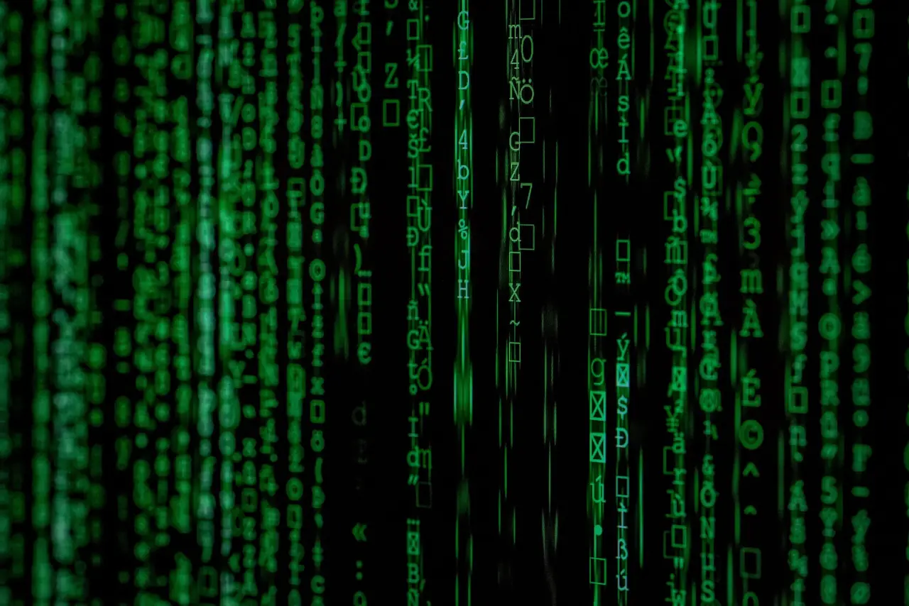 Vertical columns of glowing green digital code against a dark black background