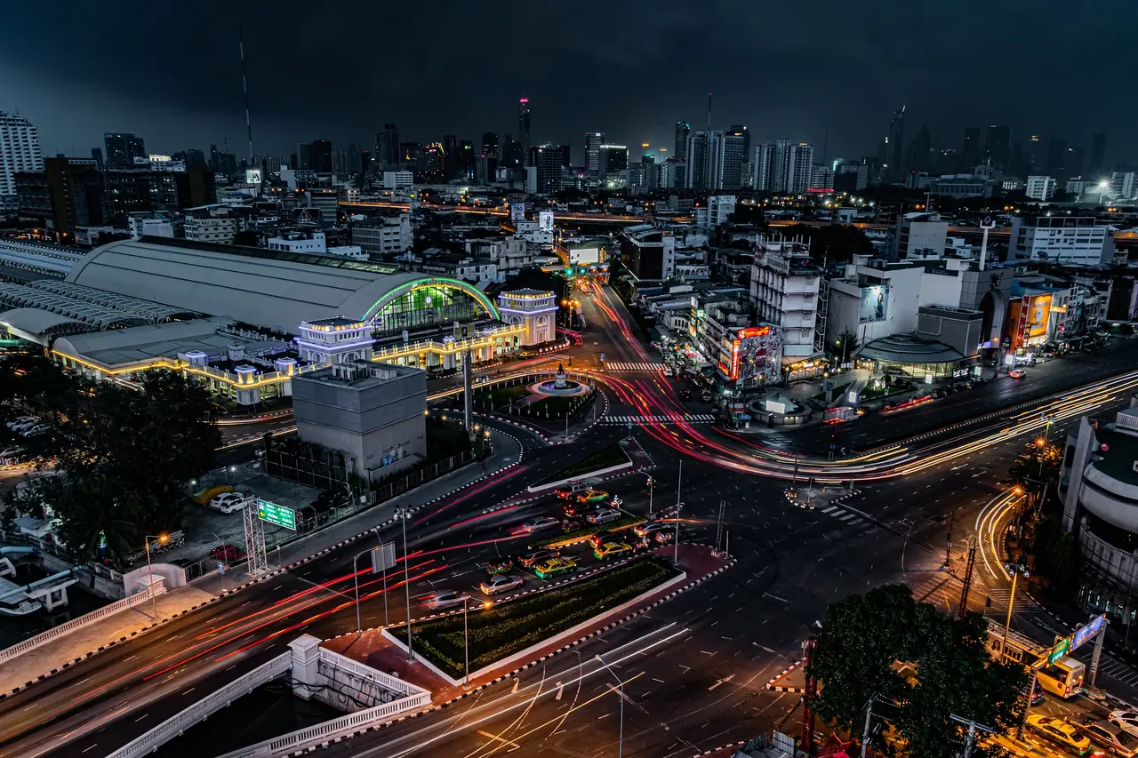 Night-time aerial view of Bangkok’s illuminated city centre and road network.