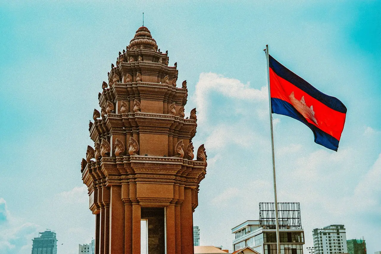 brown concrete building with flag of combodia